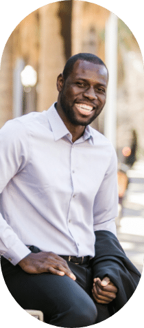 A smiling business person sat outside