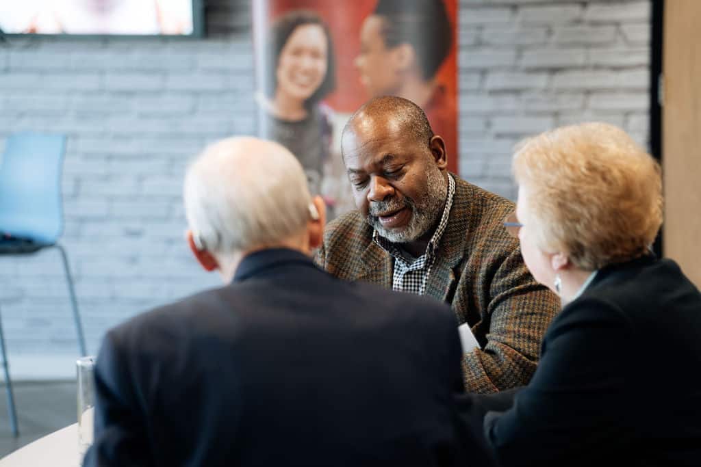 Three individuals sitting together talking